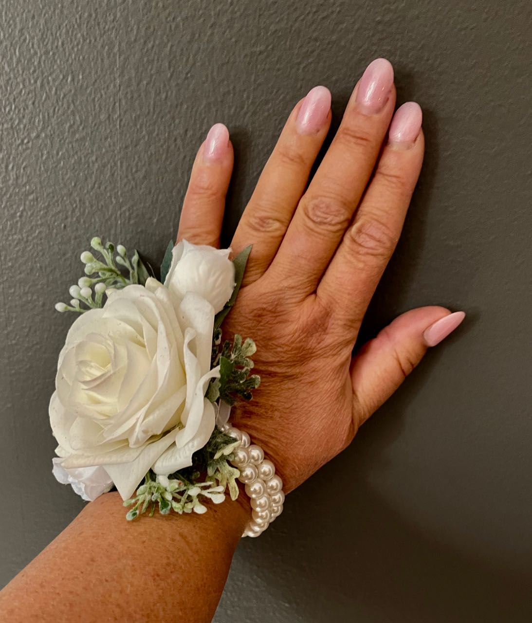 Corsage from the sage eucalyptus and white collection! One-size-fits-all dual strand pearl bracelet includes a flawless white rose, nestled between two sage green leaves and sprigs of dusty miller and two mini rose buds.