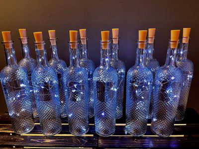 Rent A Rose- Decor-A set of a dozen 12" clear glass bottles with diamond cut detail.