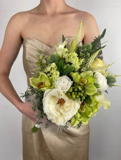 This crisp white bridesmaid bouquet combines white roses, astilbe and dark green ivy to create a simple elegant bouquet. It is finished off with a wispy white tulle base and a white satin wrapped handle. Five day rental $69.00