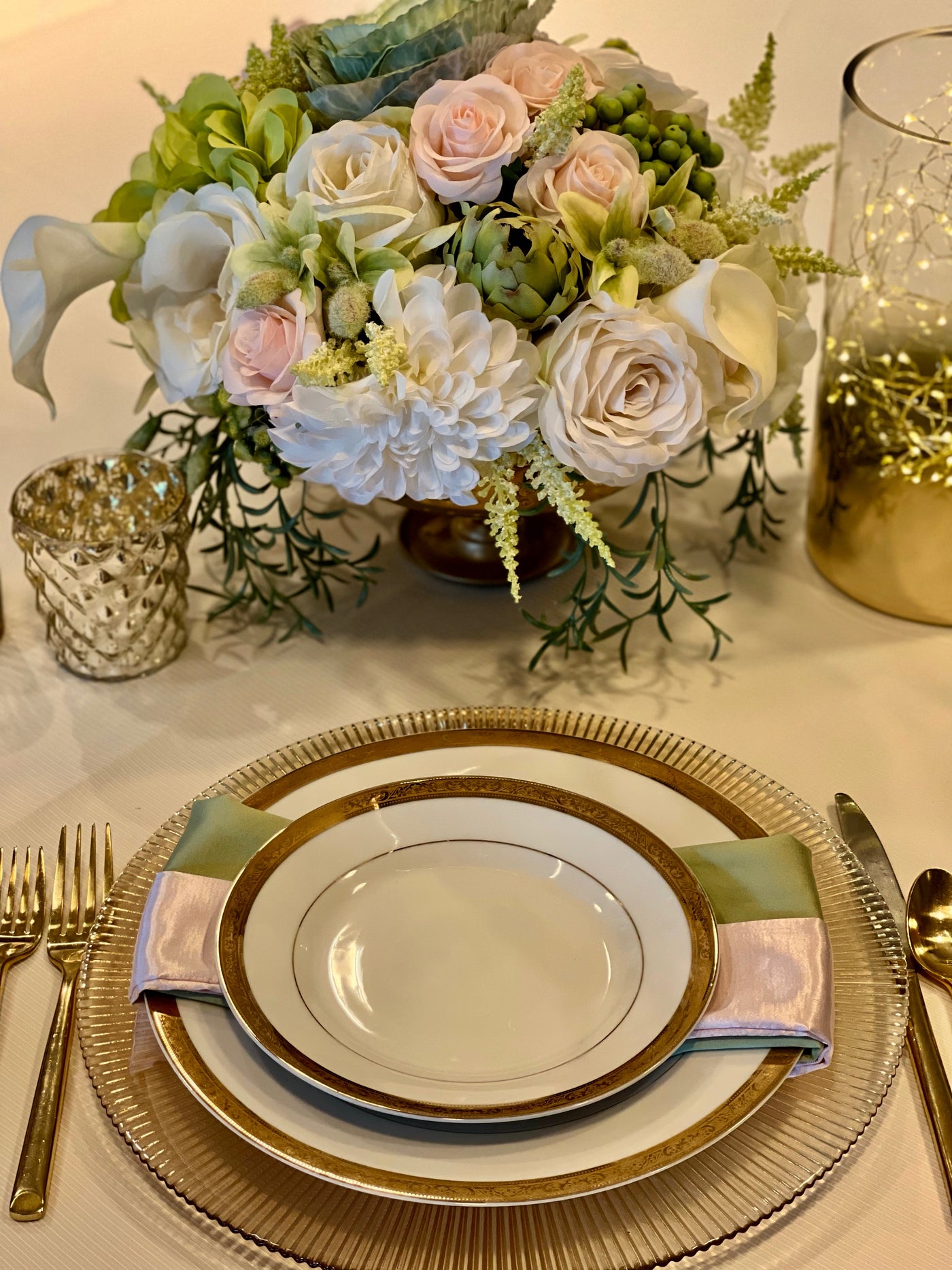 This gorgeous centrepiece is a delicate symphony of white and cream roses and huge pom pom dahlias interspersed with chartreuse hydrangea, orchid buds and green hypericum berries