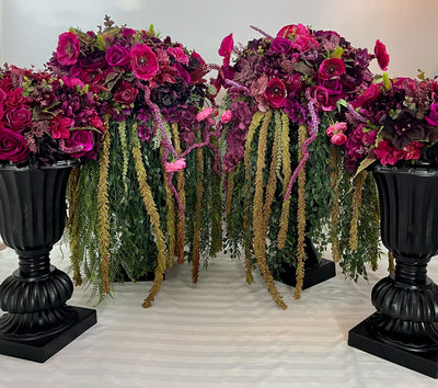 Four black planters with cascading magenta and fuchsia flowers.