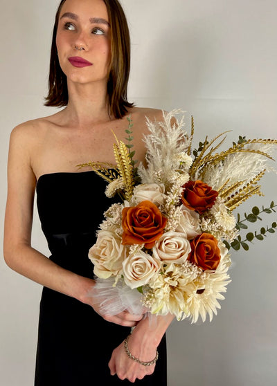Side held Bridesmaid bouquet with cream pampas, eucalyptus, cream sunflowers and roses interspersed with a beautiful pop of color from a trio of rust roses. Five day rental $59.00