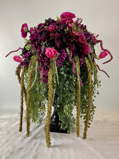 Make a bold statement with this 3 foot tall black planter overflowing with rich magenta blooms and cascading greenery.