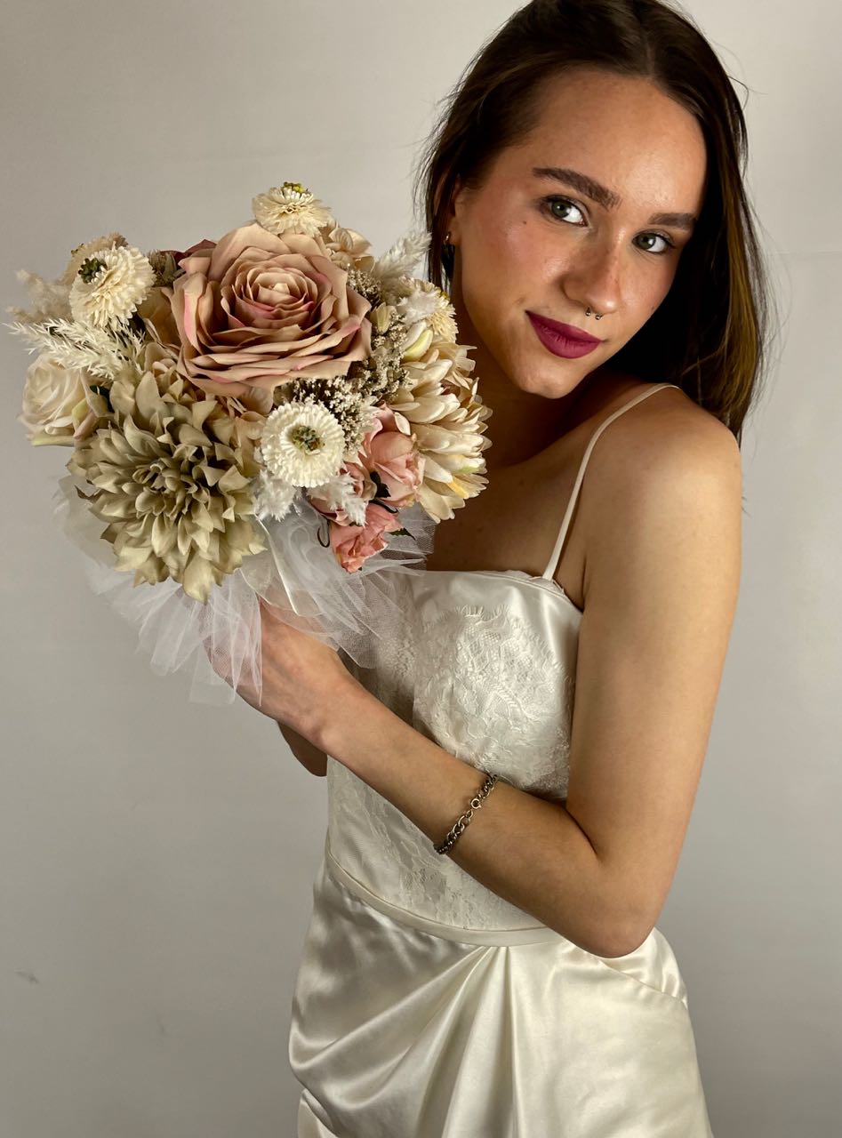 Rent a Rose 's  Cappuccino Blush collection bridesmaid bouquet skillfully blends blush pink, cream and cappuccino roses with cream pampas and the playful pop of mini beige pompom dahlias.  Rent for five days for $59.00