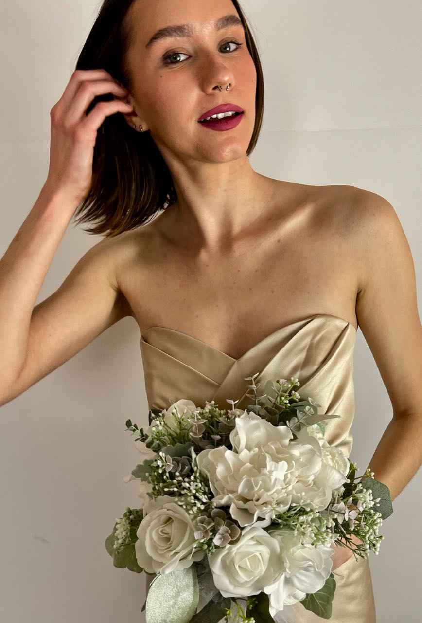 This one-of-a-kind bridesmaid bouquet is a stunning combination of timeless elegance and natural beauty. Its soft white roses, hydrangea, and dahlias pair perfectly with three shades of sage eucalyptus and a touch of dusty miller — all wrapped up in a delicate white satin ribbon and tulle for a look of sophistication on your special day!
