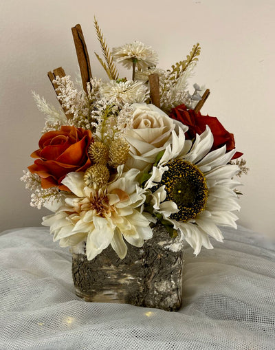 Rent A Rose This centrepiece features rust and cream roses combined with pampas, eucalyptus, and for a fun twist, cinnamon sticks, all nestled in a birch vase. The centrepiece is approx. 8 inches wide by 12 inches tall. 