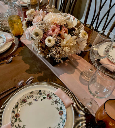 This soft-toned cream, blush and rich brown centrepiece features earth elements such as pine cones and chocolate brown pincushions. This earthy heartiness is juxtaposed with the delicate petals of large pompom dahlias, cream sunflowers, blush floribunda roses, champagne hydrangeas, and accented with cream snowberries.&nbsp; This Bohemian inspired creation is presented in an espresso stained wood box (L8”x W4”x H4”).