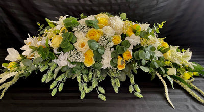 Bring a touch of nature indoors with this breathtaking floral design.  We have combined dark green eucalyptus with cream dahlias, white lilies, yellow & white roses, crisp snow white hydrangeas accented with white hypericum berries, thistle and trailing amaranth. This gorgeous floral piece measures four feet long and 16 inches wide