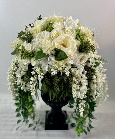 Three foot tall black urn with cascading white flowers and greenery