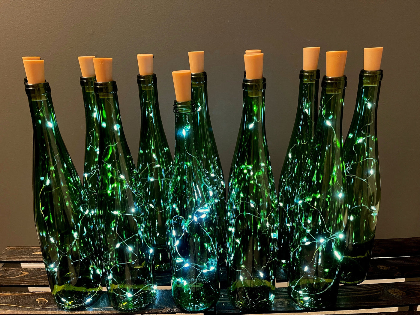 A set of a dozen 13" green glass bottles with a string of LED fairy lights that stay illuminated for 24 hours. This product is for local delivery only ( Edmonton, St. Alberta, Sherwood Park)  For venues that will not allow open flame, this is a great way to add ambience to your event.