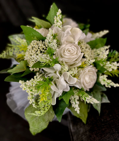 This crisp white bridesmaid bouquet combines white roses, astilbe and dark green ivy to create a simple elegant bouquet. It is finished off with a wispy white tulle base and a white satin wrapped handle. This bouquet rents for five days for $59.00