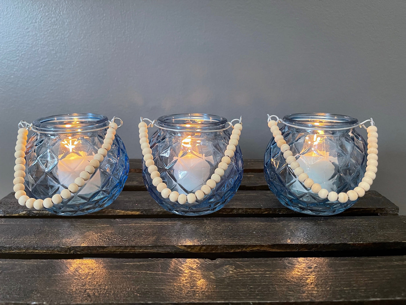 Rent a Rose- Wedding Decor-Adorable diamond patterned blue glass votive with a handle made of wood beads. The price to rent a single votive (that includes a 1 1/2 inch white candle) is $3.00. 