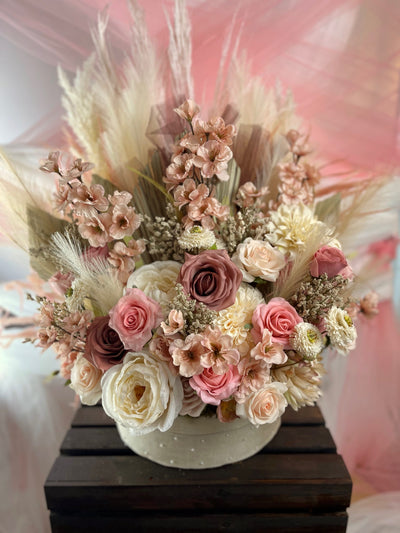 This gorgeous 2 ft x 2 ft circular floral creation can be used at the base of an arch or at the bottom of a sweetheart table, or in fact anywhere you wish. It combines pampas, feathers, fans roses, dahlias and peonies. The base is covered in beige linen and pearl stickpins.