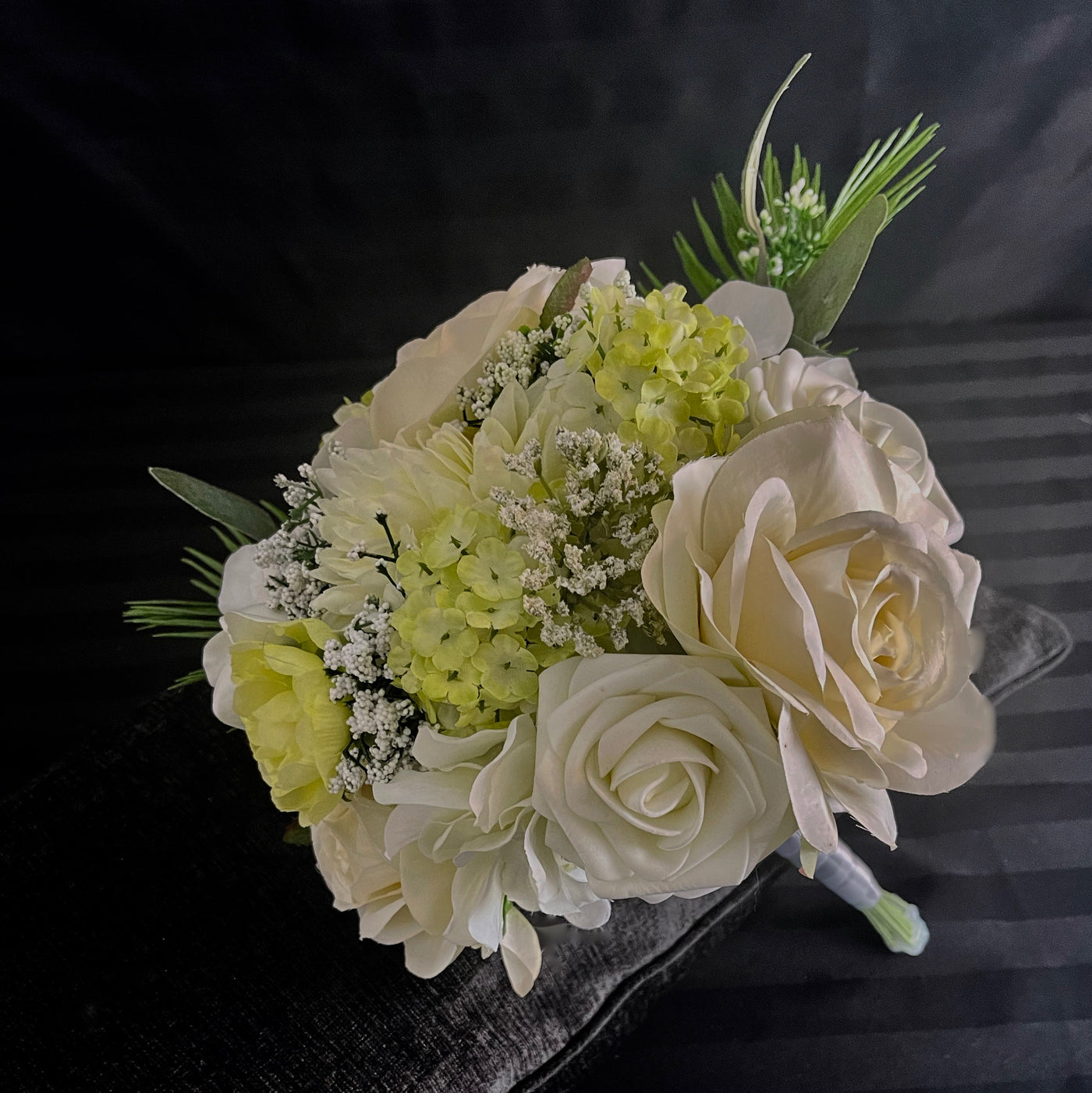 This bridesmaid bouquet combines white roses, hydrangea and dahlias with pale green cabbage roses to create this classic bouquet. Additional visual interest is provided by green and cream berries, ferns and seeded eucalyptus. Rent for five days for $19.00