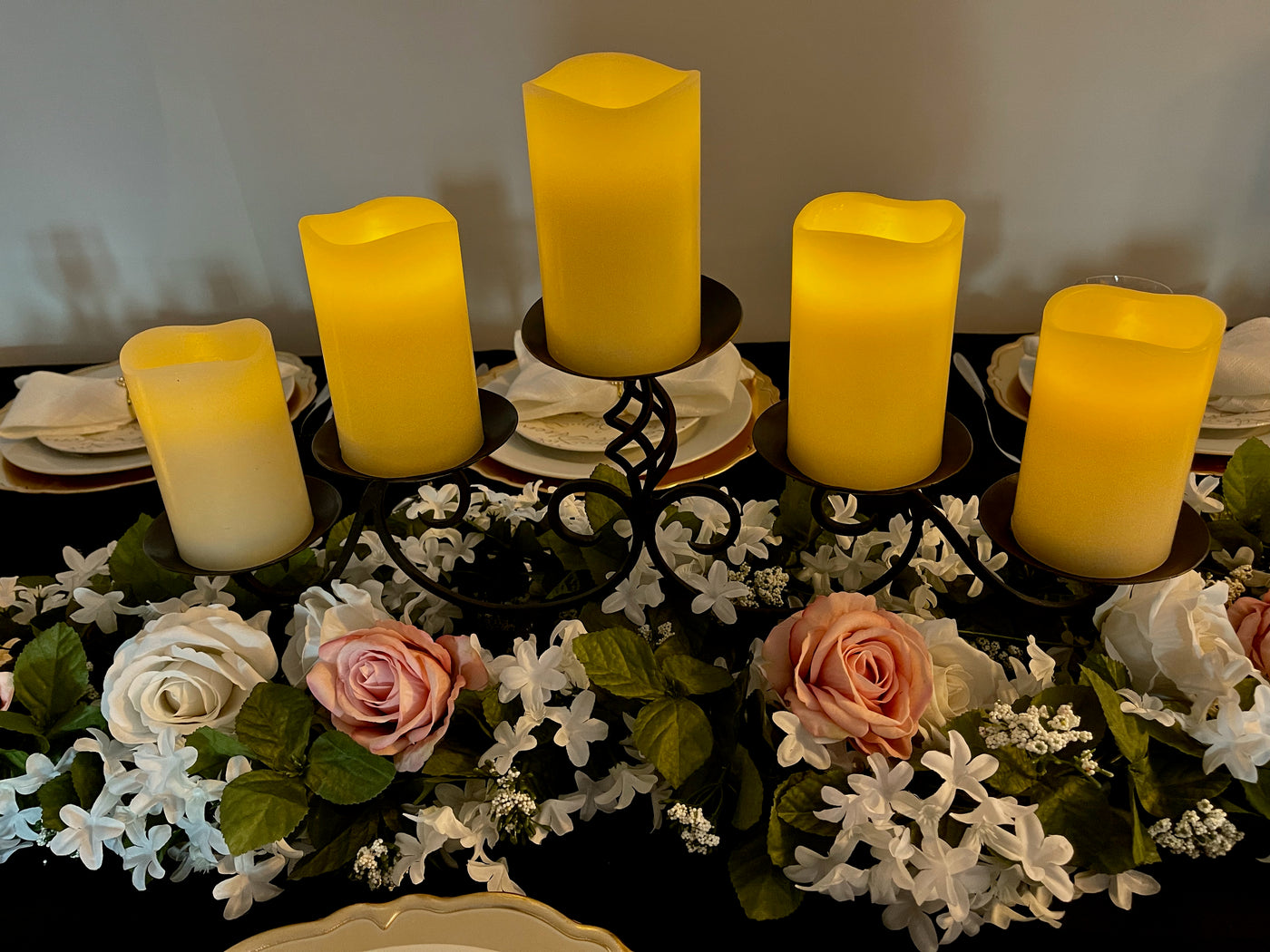 Black wrought iron candelabra including five LED remote controlled candles. One button turns all candles on and off, setting the mood perfectly for your event.