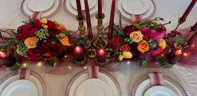 Rent a Rose- Centrepiece- Orange, Burgundy, and Fuchsia- flowers with Olive green berries rent for five days for $20.00