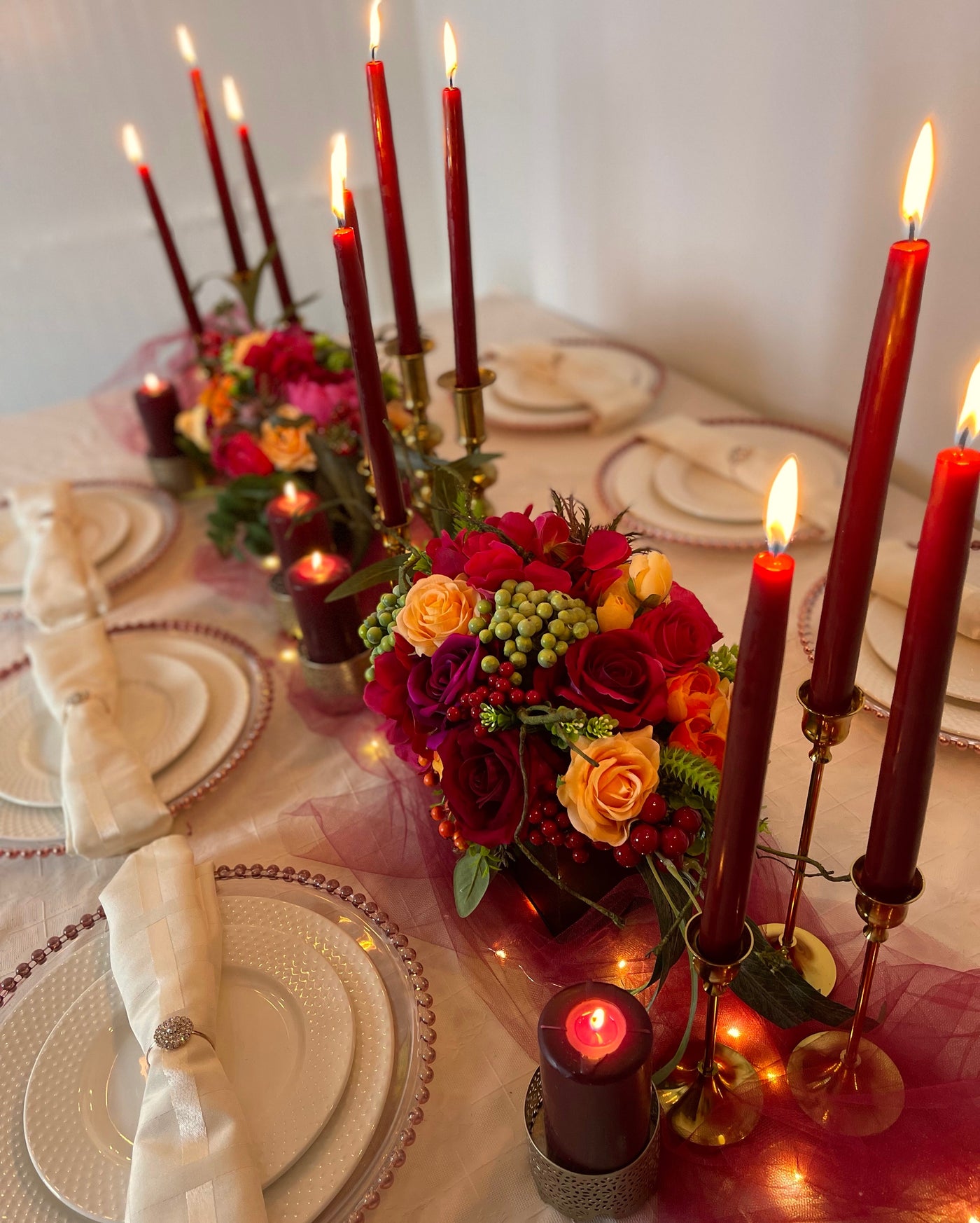 Rent a Rose- Centrepiece- Orange, Burgundy, and Fuchsia- flowers with Olive green berries rent for five days for $54.00.