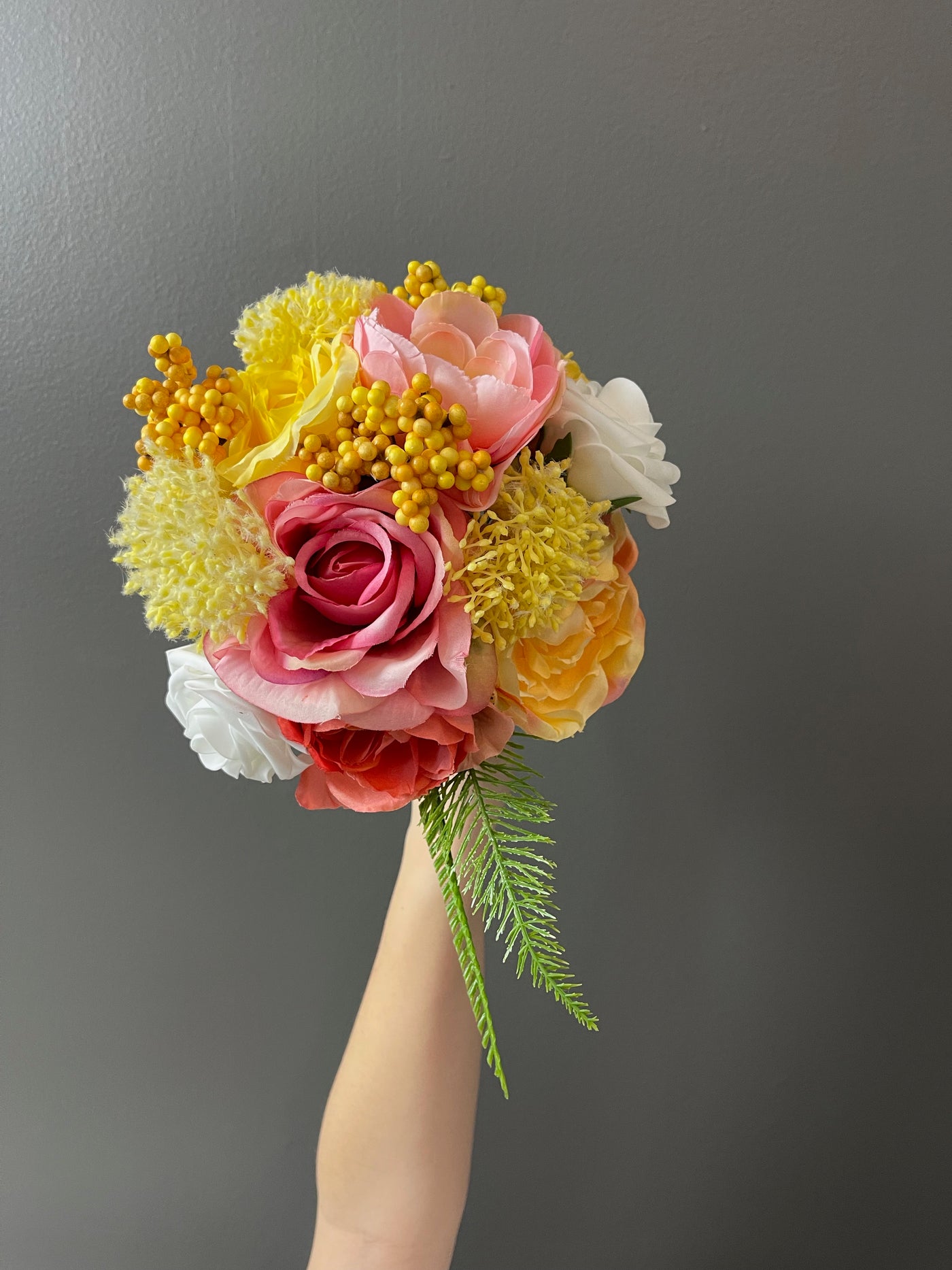 This warm summer collection features large pink and yellow peony blossoms which open gracefully next to custard hydrangeas, peach English roses, white globe dahlias, and yellow hypericum berries, and sprigs of bright green fern.