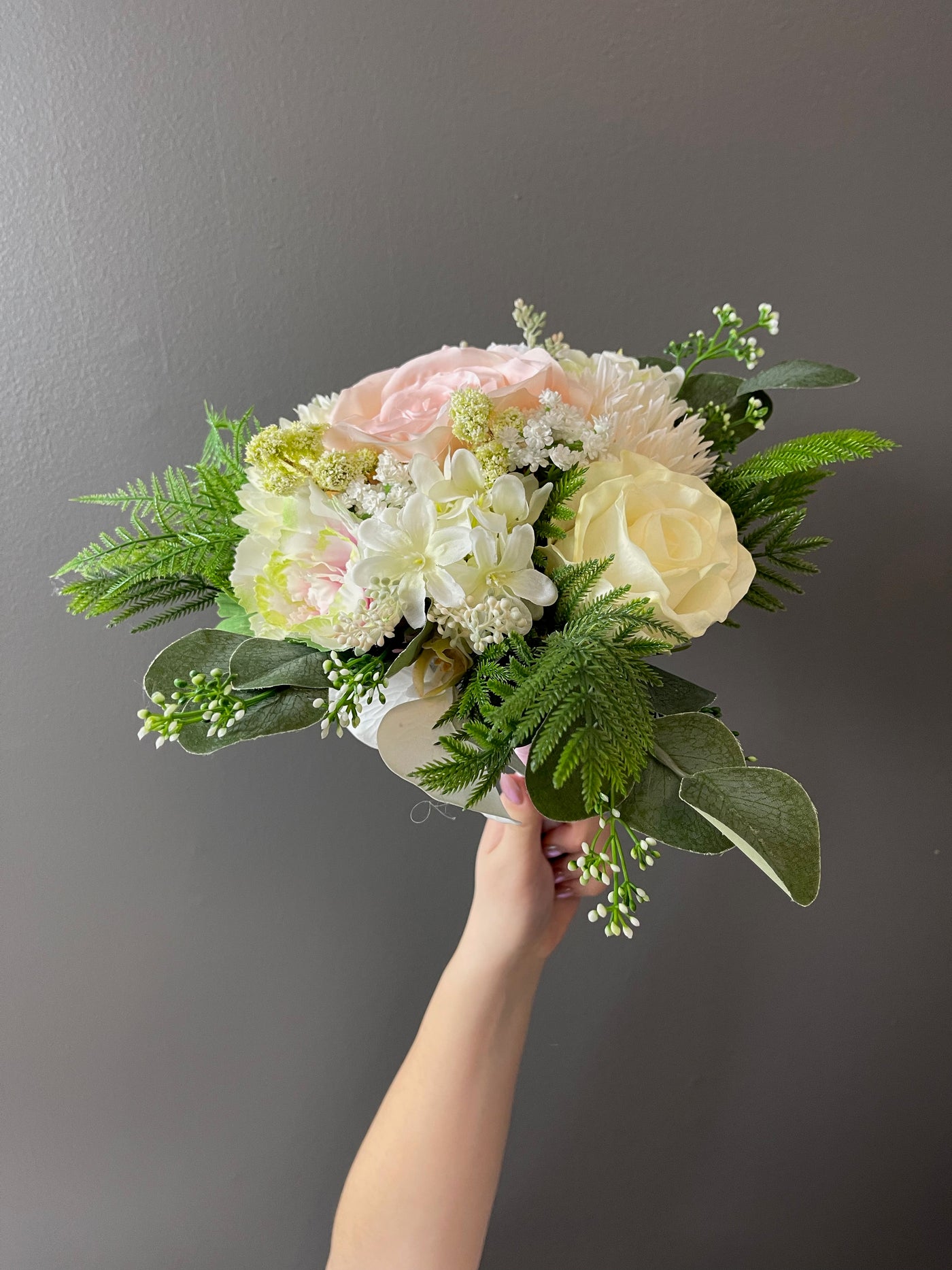 This soft pastel collection is the perfect whisper of elegance featuring pale pink roses, blush dahlias, delicate white peonies, pale pink cabbage roses, white sweet peas, hydrangeas, baby’s breath, and accented with miniature viburnum. These elegant blossoms are surrounded by seeded eucalyptus.  These smaller "flower girl" bouquets are 12" (varying slightly in size depending on the protruding foliage)
