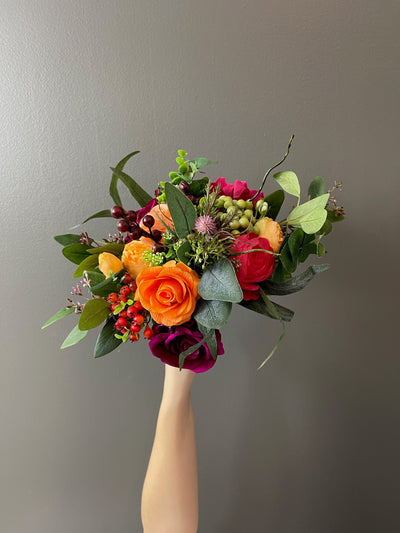 This dramatic collection marries vivid, rich purples with warm, bright oranges. Featuring a variety of jewel-toned roses from eggplant to fuchsia, apricot ranunculus, scarlet hydrangea, orange and green and crimson hypericum berries, purple thistle, and raspberry peony surrounded by a bed of deep green myrtle leaves, seeded eucalyptus and sprigs of wavy amaranth.  These smaller "flower girl" bouquets are 12" (varying slightly in size depending on the protruding foliage)