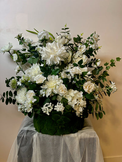 Round white floral arrangement that is approx .4 feet tall by 3 feet wide. Perfect to be sued on either side of an alter at a church ceremony.