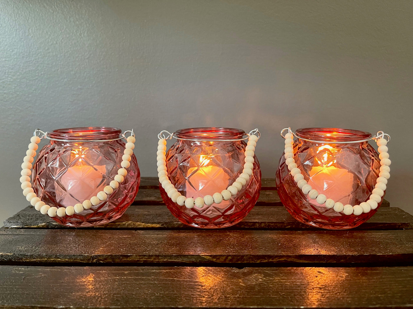 Rent a Rose- Wedding Decor-Adorable diamond patterned pink glass votive with a handle made of wood beads. The price to rent a single votive including candle is $3.00