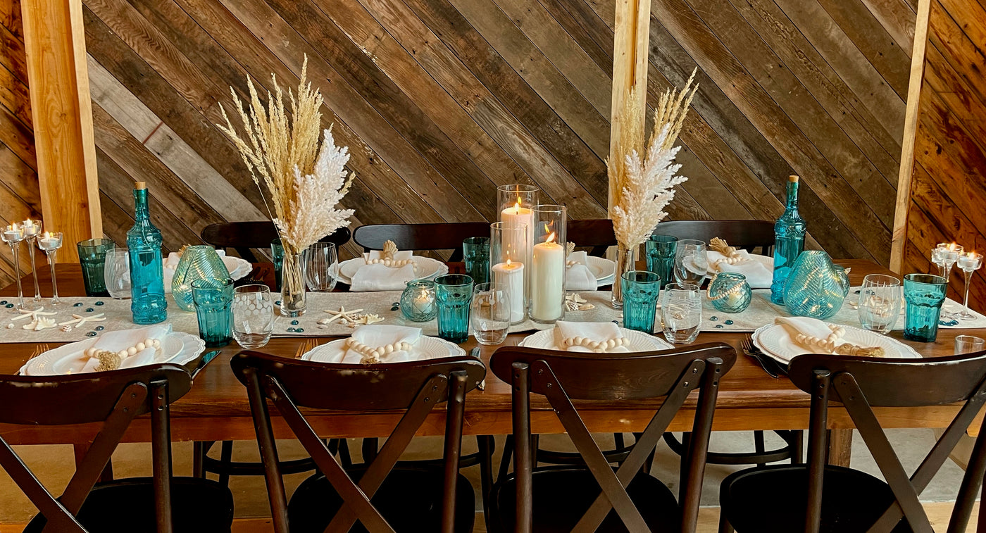 Beach themed table scape with teal glass ware and pamps and wheat glass  in a champaign flute serving as a simple elegant centrepiece.