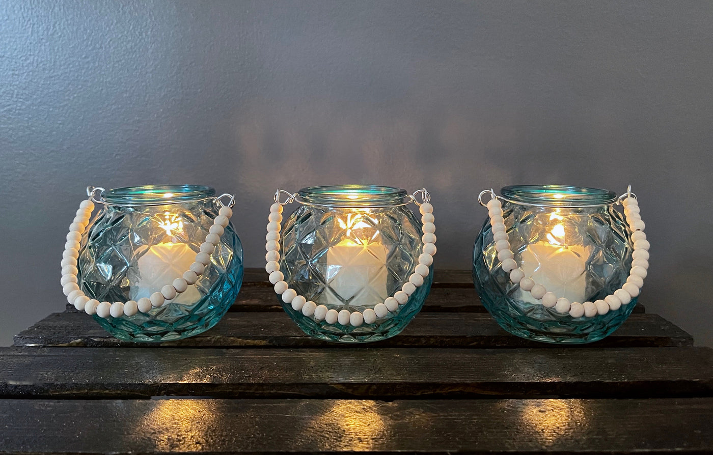 Rent a Rose- Wedding Decor-Adorable diamond patterned Teal glass votive with a handle made of wood beads. The price to rent a single votive including candle is $3.00