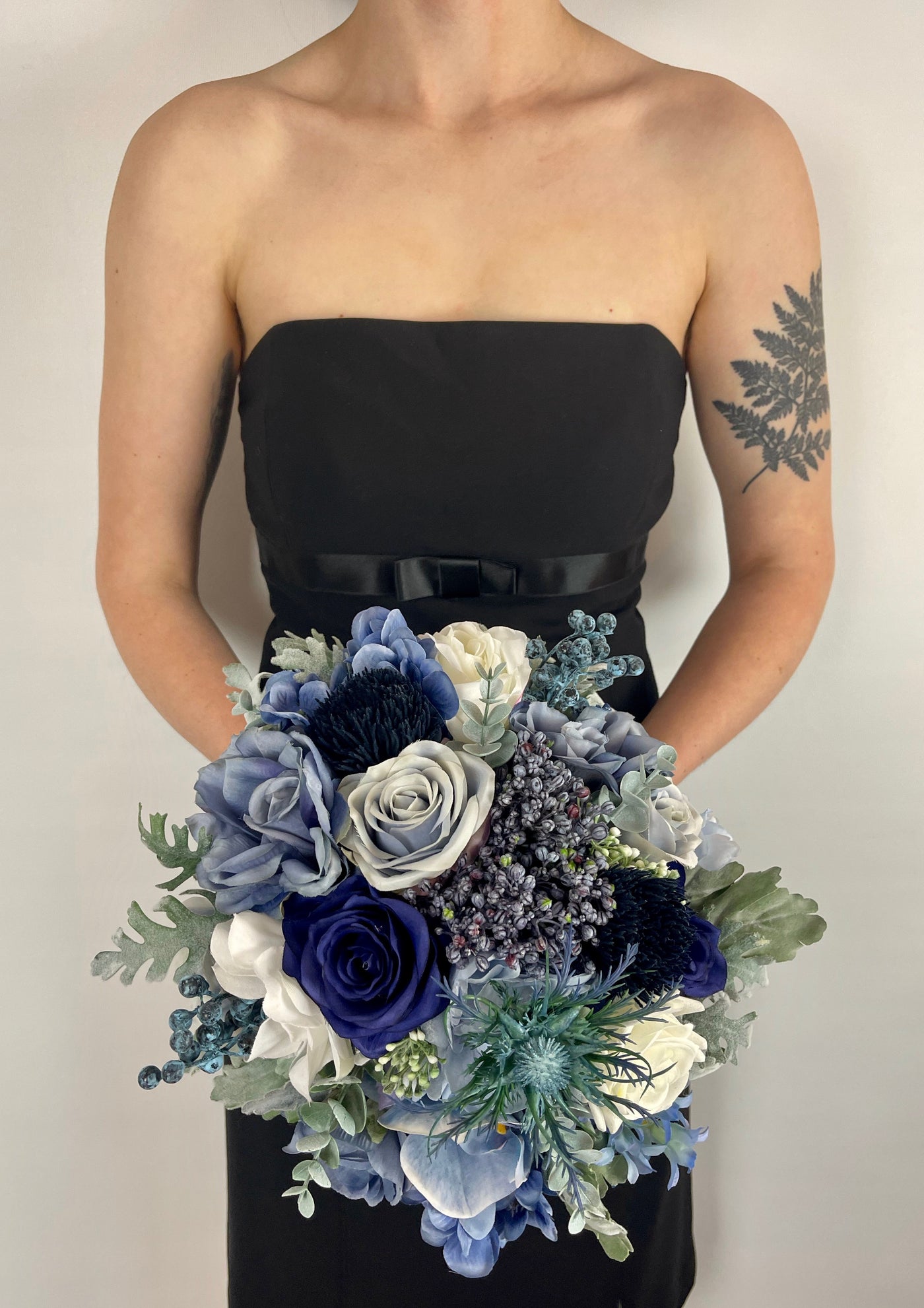Bridesmaid bouquet made with faux blue flowers. This bouquet  features himalayan blue poppies, delphiniums, hyacinth, and peonies together. To add texture and interest we added elderberries, oxford blue thistle and eucalyptus springs. five day rental for $69.00