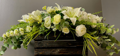 This five foot long centrepiece is a glorious mass of white lilies, orchids and roses all nestled in a bed of various types of eucalyptus. This arrangement is perfect for a sweetheart head table, as the flowers are low enough as to not obscure the bride and groom for photos.